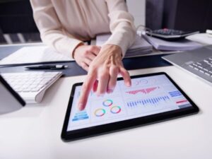 Una mano indica dati finanziari su un tablet durante una consulenza per mutuo.