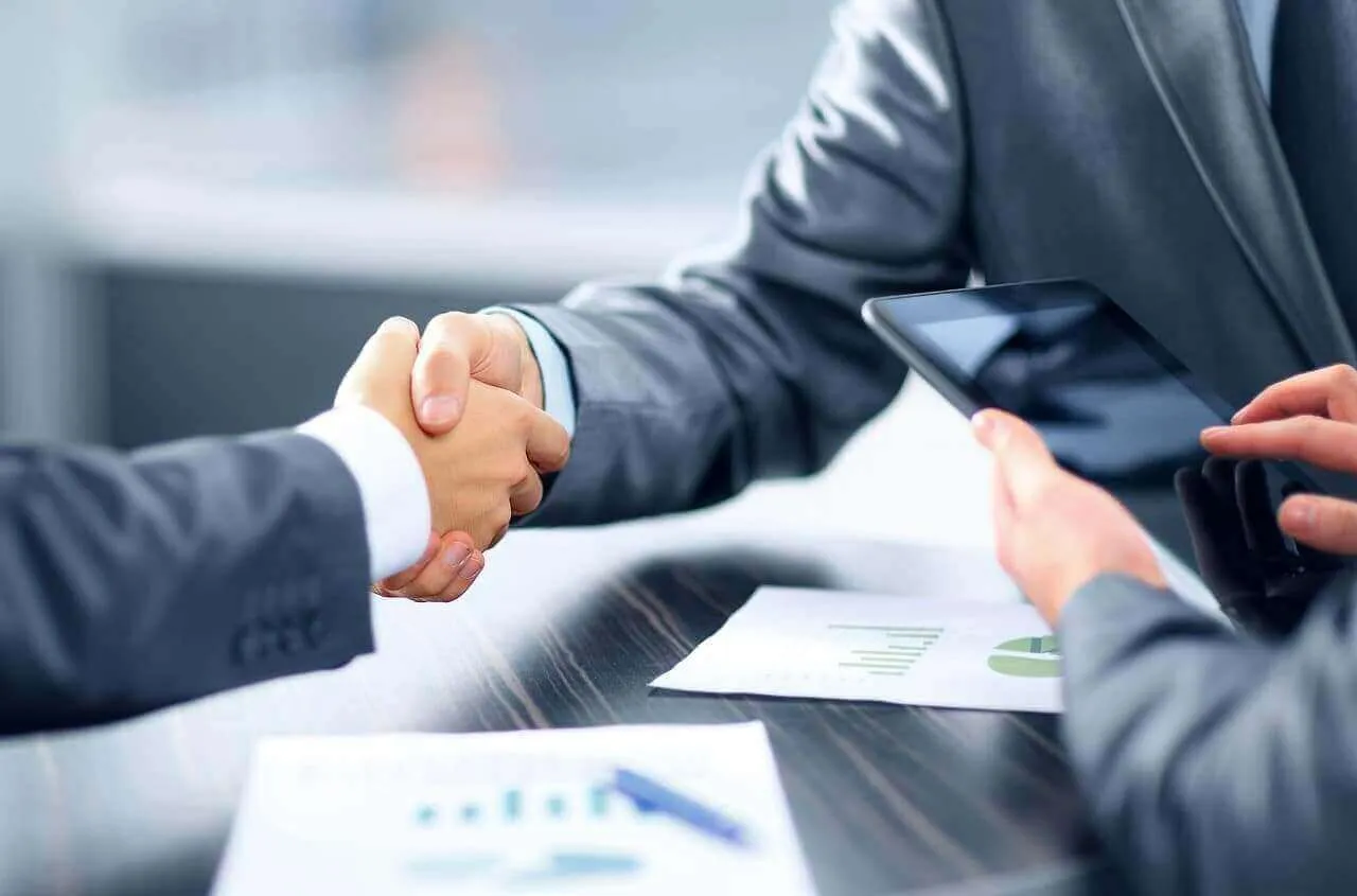 Stretta di mano tra due professionisti in ufficio